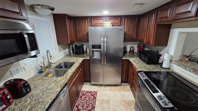 1805 Stoney Brook Dr Unit 103, Houston, TX 77063 - kitchen featuring appliances with stainless steel finishes, a sink, and light stone countertops