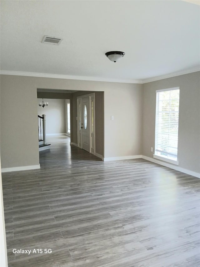 17931 Elk River Cir, Houston, TX 77090 - unfurnished living room with crown molding, baseboards, wood finished floors, and a chandelier