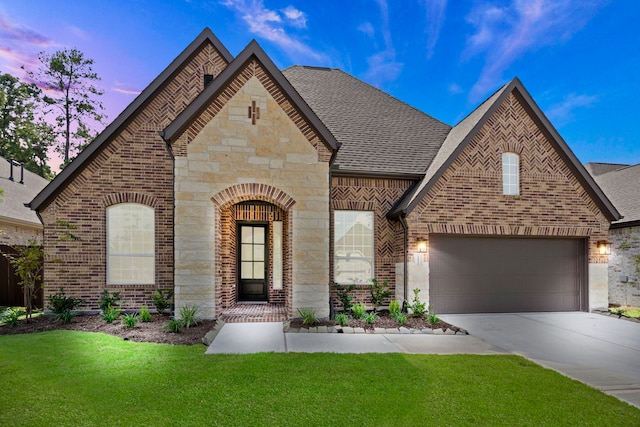 16154 Rustling Woods Rd, Conroe, TX 77302 - french country home with driveway, brick siding, stone siding, a front yard, and a garage