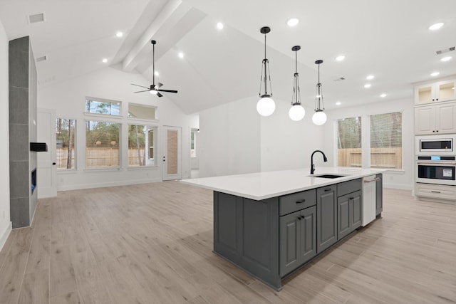 16154 Rustling Woods Rd, Conroe, TX 77302 - kitchen featuring white appliances, gray cabinetry, a sink, open floor plan, and light countertops