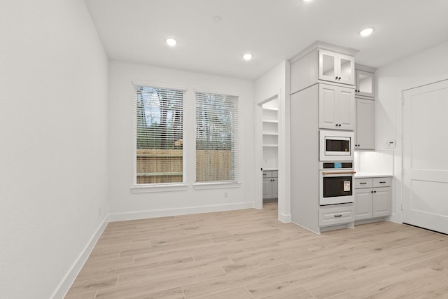 16154 Rustling Woods Rd, Conroe, TX 77302 - kitchen with white appliances, light wood-style floors, baseboards, and recessed lighting
