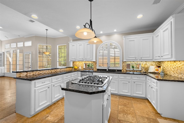 6910 Amber Ct, Houston, TX 77069 - kitchen featuring stainless steel gas cooktop, a sink, ornamental molding, a peninsula, and healthy amount of natural light