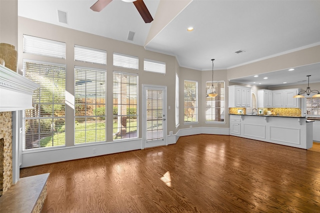 6910 Amber Ct, Houston, TX 77069 - unfurnished living room featuring wood finished floors, a ceiling fan, a fireplace, crown molding, and healthy amount of natural light