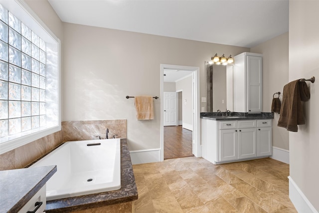 6910 Amber Ct, Houston, TX 77069 - bathroom featuring plenty of natural light, a tub to relax in, vanity, and baseboards