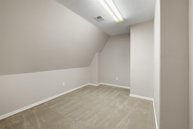 6910 Amber Ct, Houston, TX 77069 - additional living space with light colored carpet, baseboards, a textured ceiling, and vaulted ceiling