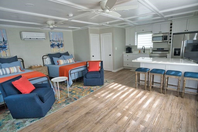 450 County Road 206, Sargent, TX 77414 - bedroom featuring stainless steel fridge, a sink, an AC wall unit, light wood-type flooring, and a ceiling fan