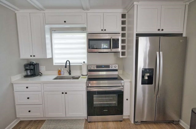 450 County Road 206, Sargent, TX 77414 - kitchen featuring appliances with stainless steel finishes, a sink, white cabinets, light countertops, and crown molding
