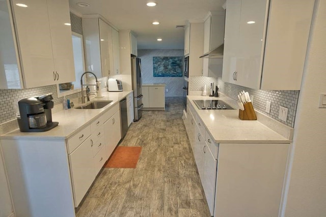 450 County Road 206, Sargent, TX 77414 - kitchen featuring a sink, black appliances, light wood-style floors, white cabinetry, and light countertops
