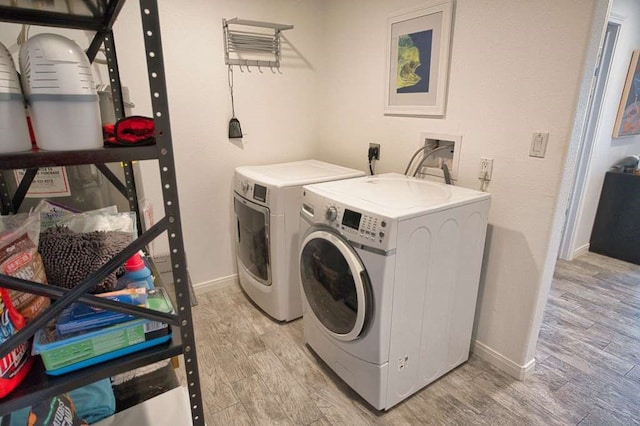 450 County Road 206, Sargent, TX 77414 - clothes washing area featuring washer and clothes dryer, light wood-style flooring, and baseboards