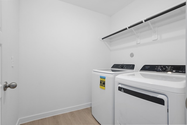 305 Robin St, Angleton, TX 77515 - laundry room with washer and dryer, light wood-type flooring, and baseboards