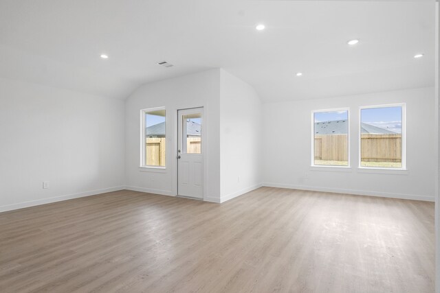305 Robin St, Angleton, TX 77515 - unfurnished living room featuring vaulted ceiling, plenty of natural light, light wood-style floors, recessed lighting, and baseboards