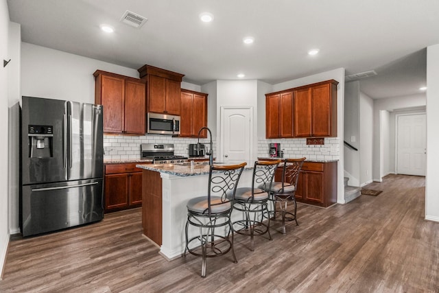 819 Spruce Pine Dr, Conroe, TX 77318 - kitchen with stainless steel appliances, a sink, light stone countertops, backsplash, and dark wood finished floors