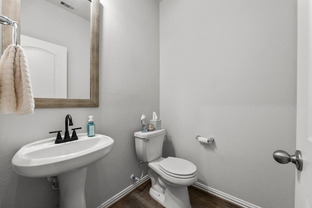 819 Spruce Pine Dr, Conroe, TX 77318 - bathroom featuring wood finished floors, baseboards, and toilet