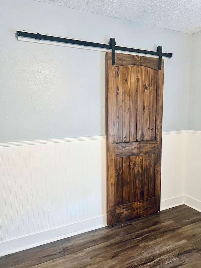 1301 Cherie Brook Dr, Goliad, TX 77963 - detailed view of wood finished floors, a wainscoted wall, baseboards, and a barn door