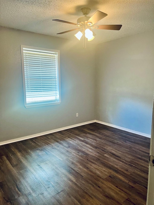 1301 Cherie Brook Dr, Goliad, TX 77963 - unfurnished room with dark wood-type flooring, a ceiling fan, a textured ceiling, and baseboards