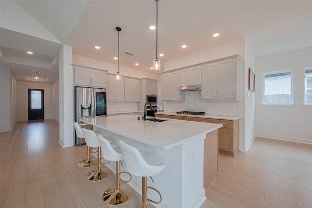 2610 Texas Orange Trl, Richmond, TX 77406 - kitchen with stainless steel refrigerator with ice dispenser, a sink, cooktop, tasteful backsplash, and light countertops