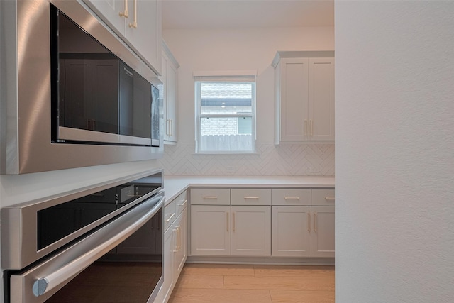 2610 Texas Orange Trl, Richmond, TX 77406 - kitchen with appliances with stainless steel finishes, decorative backsplash, light countertops, and white cabinets