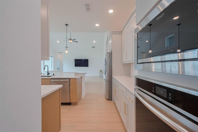 2610 Texas Orange Trl, Richmond, TX 77406 - kitchen featuring stainless steel appliances, light countertops, open floor plan, a sink, and ceiling fan