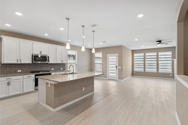 24730 Harbor Terrace Ln, Richmond, TX 77406 - kitchen with stainless steel microwave, range, decorative backsplash, light wood-style flooring, and recessed lighting