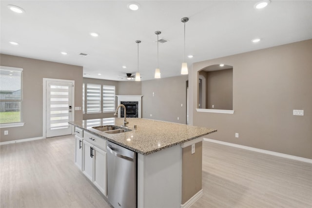 24730 Harbor Terrace Ln, Richmond, TX 77406 - kitchen featuring stainless steel dishwasher, a sink, light wood-style flooring, a premium fireplace, and recessed lighting