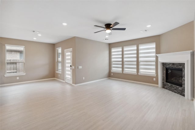 24730 Harbor Terrace Ln, Richmond, TX 77406 - unfurnished living room featuring a premium fireplace, plenty of natural light, light wood-type flooring, and recessed lighting