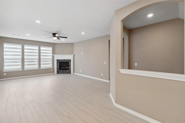 24730 Harbor Terrace Ln, Richmond, TX 77406 - unfurnished living room with a ceiling fan, baseboards, arched walkways, light wood finished floors, and recessed lighting