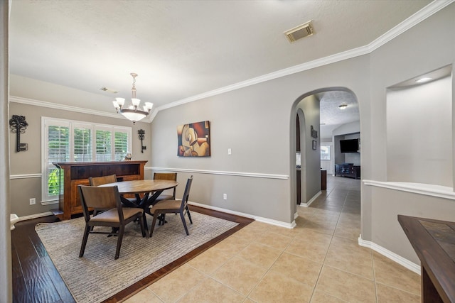 8514 Babbling Brook Ct, Sugar Land, TX 77479 - dining area featuring arched walkways, light tile patterned floors, baseboards, and crown molding