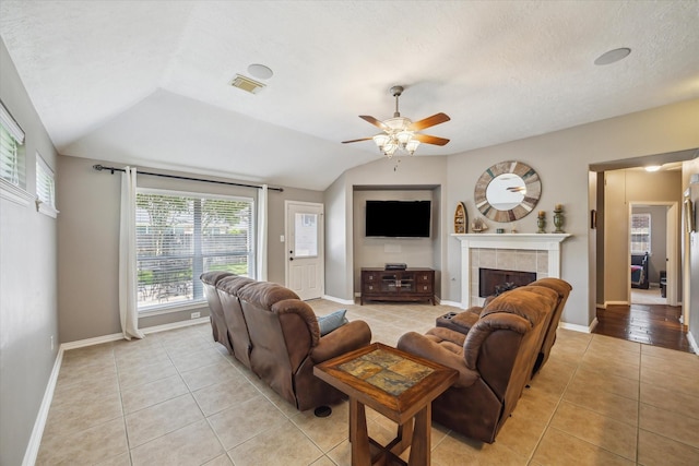 8514 Babbling Brook Ct, Sugar Land, TX 77479 - living area featuring light tile patterned floors, ceiling fan, a tile fireplace, vaulted ceiling, and baseboards