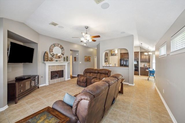 8514 Babbling Brook Ct, Sugar Land, TX 77479 - living room featuring lofted ceiling, light tile patterned floors, ceiling fan, a tiled fireplace, and arched walkways