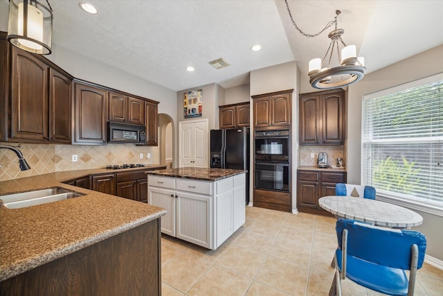 8514 Babbling Brook Ct, Sugar Land, TX 77479 - kitchen with a sink, black appliances, dark brown cabinetry, decorative backsplash, and arched walkways