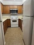 3100 Walnut Bend Ln Unit 508, Houston, TX 77042 - kitchen featuring white appliances, brown cabinets, and light countertops