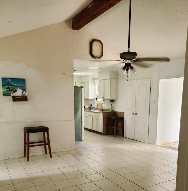 4826 Macridge Blvd, Houston, TX 77053 - kitchen featuring a ceiling fan, freestanding refrigerator, white cabinets, a kitchen bar, and light tile patterned floors