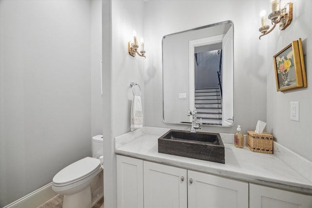 bathroom featuring toilet, vanity, and baseboards