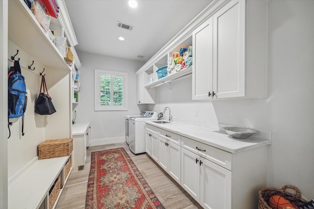 laundry area featuring cabinet space, washing machine and dryer, light wood-style floors, recessed lighting, and baseboards