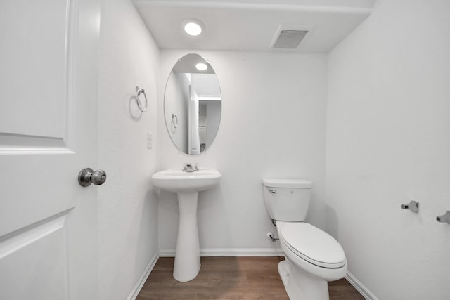 24063 Hawthorn Lakes Dr, New Caney, TX 77357 - half bathroom featuring wood finished floors, toilet, baseboards, and a sink