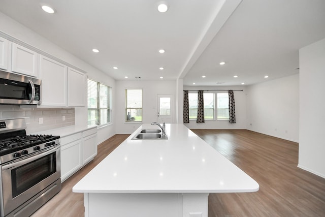 24063 Hawthorn Lakes Dr, New Caney, TX 77357 - kitchen featuring stainless steel appliances, a sink, light wood-style flooring, plenty of natural light, and recessed lighting
