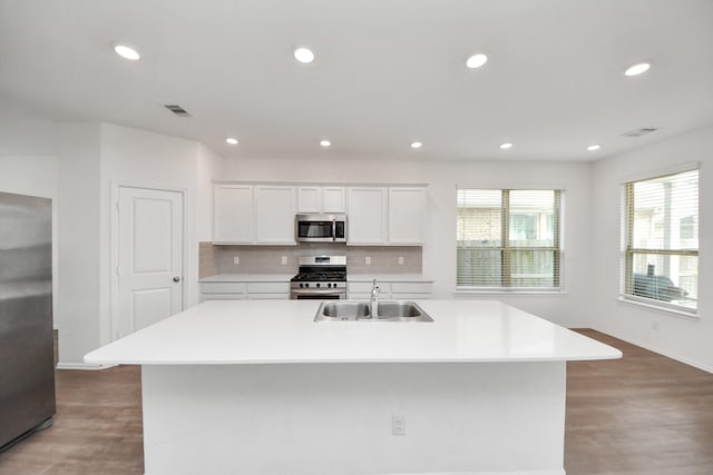 24063 Hawthorn Lakes Dr, New Caney, TX 77357 - kitchen with appliances with stainless steel finishes, baseboards, light wood finished floors, a sink, and light countertops