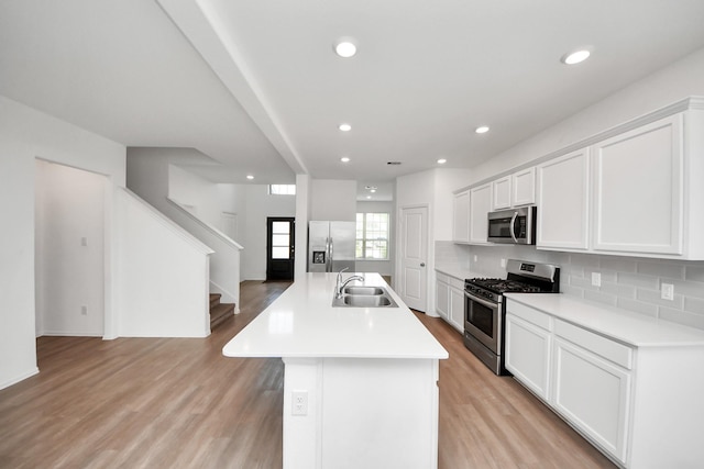 24063 Hawthorn Lakes Dr, New Caney, TX 77357 - kitchen featuring appliances with stainless steel finishes, a sink, decorative backsplash, a center island with sink, and recessed lighting