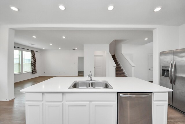 24063 Hawthorn Lakes Dr, New Caney, TX 77357 - kitchen featuring stainless steel appliances, a sink, open floor plan, recessed lighting, and white cabinets