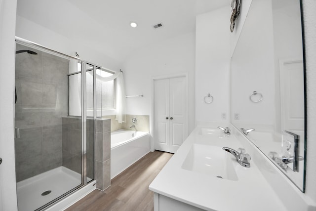 24063 Hawthorn Lakes Dr, New Caney, TX 77357 - bathroom featuring wood finished floors, a shower stall, a garden tub, double vanity, and recessed lighting