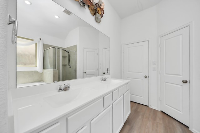 24063 Hawthorn Lakes Dr, New Caney, TX 77357 - full bathroom with a shower stall, double vanity, wood finished floors, and recessed lighting
