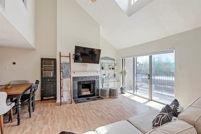 2300 Old Spanish Trl Unit 2059, Houston, TX 77054 - living area with high vaulted ceiling, light wood-style floors, a fireplace, and baseboards