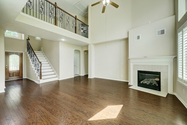 24635 Blue Opal Ln, Katy, TX 77494 - unfurnished living room featuring a towering ceiling, stairway, arched walkways, wood finished floors, and ceiling fan