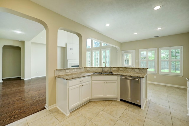 24635 Blue Opal Ln, Katy, TX 77494 - kitchen featuring stainless steel dishwasher, a sink, arched walkways, plenty of natural light, and recessed lighting