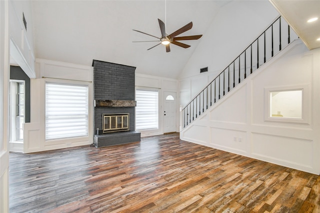 55 Willow Ct, Lake Jackson, TX 77566 - unfurnished living room with a decorative wall, a ceiling fan, stairway, wood finished floors, and high vaulted ceiling