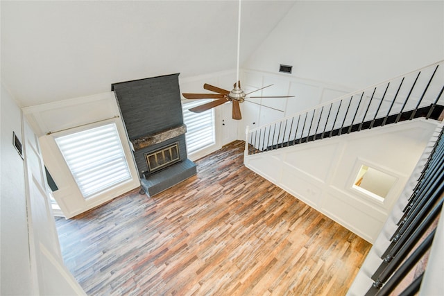 55 Willow Ct, Lake Jackson, TX 77566 - unfurnished living room featuring ceiling fan, light wood-style floors, stairway, a fireplace, and a decorative wall