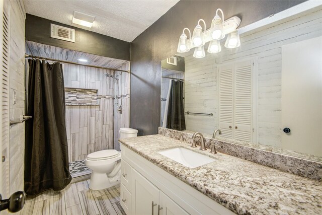 55 Willow Ct, Lake Jackson, TX 77566 - bathroom featuring toilet, a textured ceiling, vanity, a shower with shower curtain, and a closet