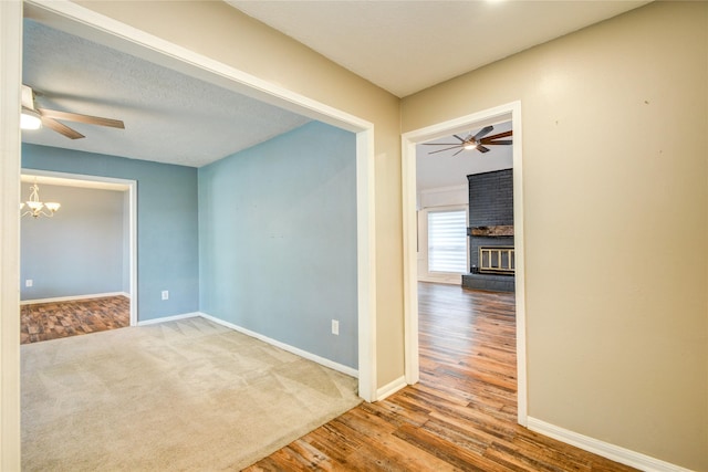 55 Willow Ct, Lake Jackson, TX 77566 - empty room featuring ceiling fan, a brick fireplace, a chandelier, and baseboards
