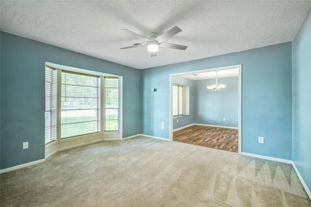 55 Willow Ct, Lake Jackson, TX 77566 - carpeted spare room with a chandelier, a ceiling fan, baseboards, healthy amount of natural light, and a textured ceiling