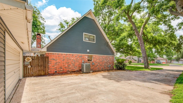 55 Willow Ct, Lake Jackson, TX 77566 - view of home's exterior featuring brick siding, central air condition unit, and a chimney